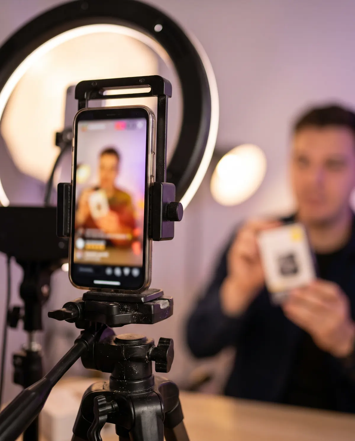 Phone on a tripod streaming live in front of a ring light